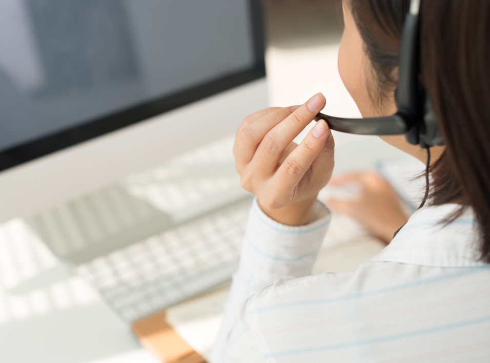 Woman with a headset providing technical support at a computer